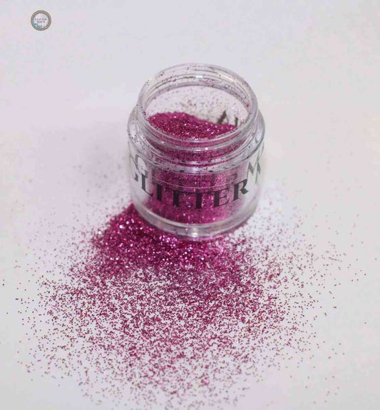 Glitter Mafia Benny Loose Glitter in vibrant pink spilled from a small clear jar on white background