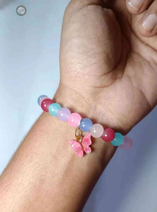 Colorful beaded butterfly bracelet featuring a pink butterfly charm on wrist