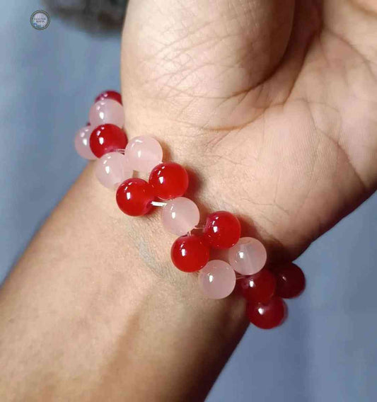 Glitter Mafia cross bracelet with red and pink round beads on wrist