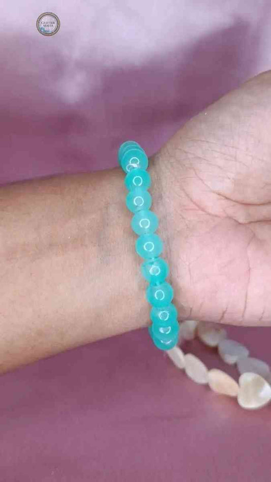 Glitter Mafia dark green bracelet made of round beads worn on wrist over purple background