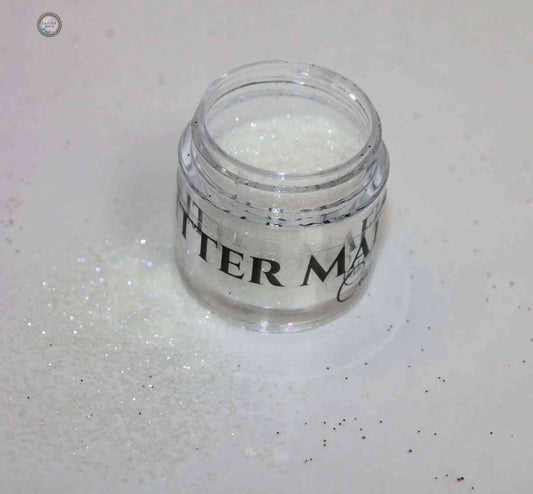 Glitter Mafia Faking It Loose Glitter in a clear jar with sparkly white loose glitter spilled around