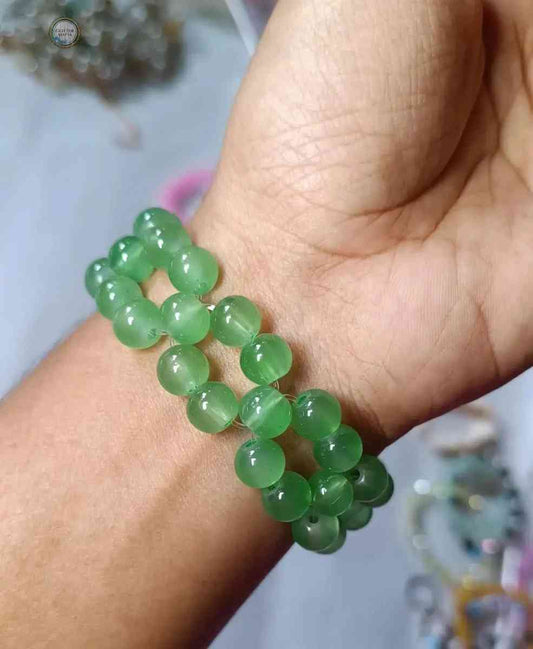 Green beaded flower bracelet by Glitter Mafia worn on wrist with round translucent beads