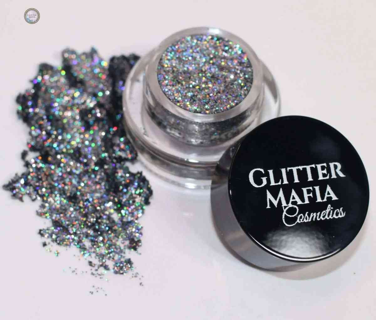 Glitter Mafia Moonstone Pressed Glitter in clear jar with black lid and spilled glitter on white background