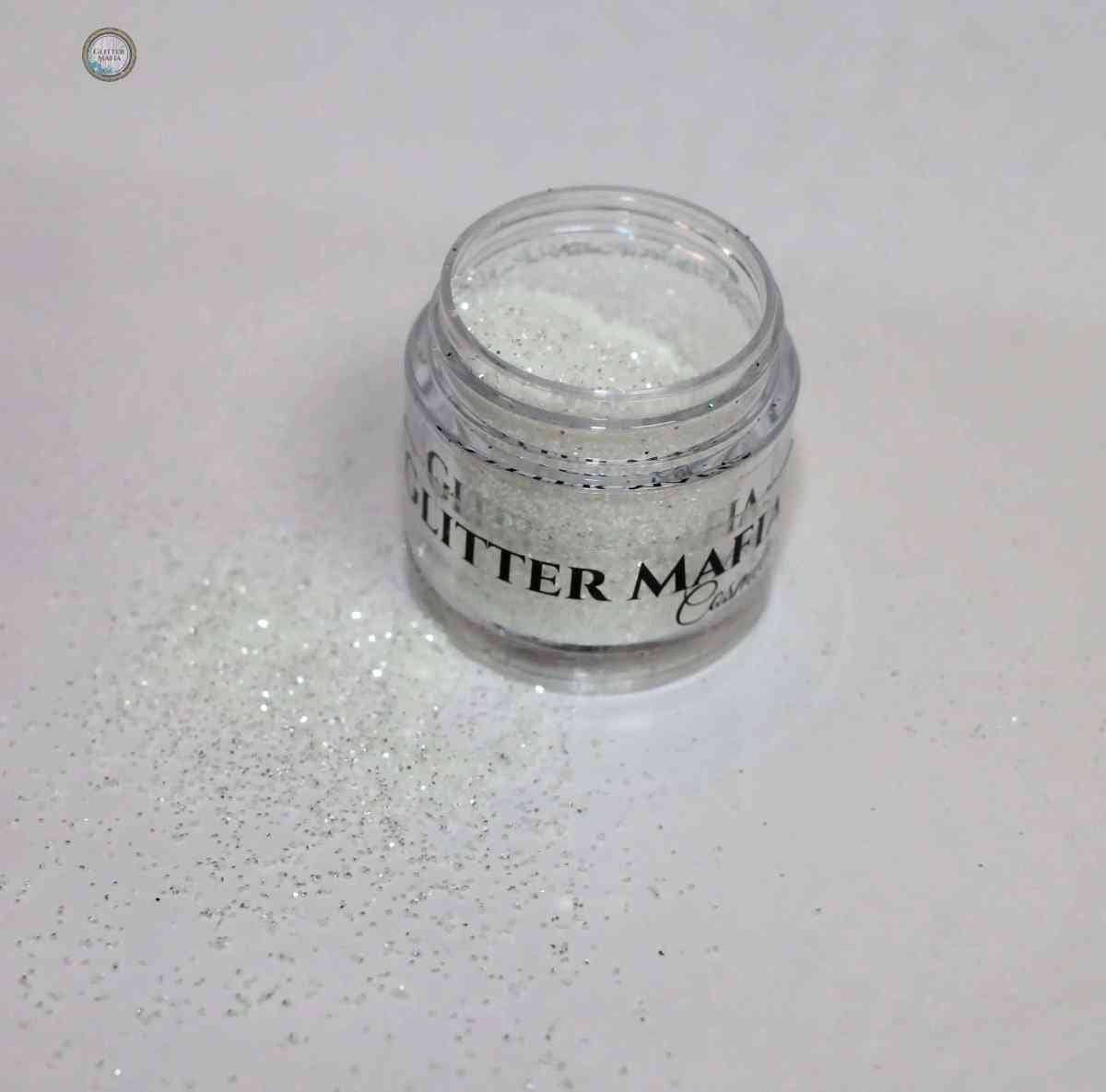 Glitter Mafia jar of Diamond Loose Glitter with sparkling white glitter spilled on white surface