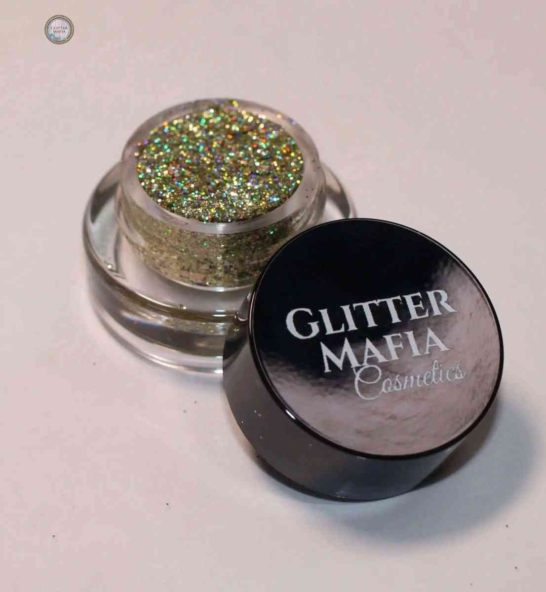 Glitter Mafia Luna Pressed Glitter in mini clear container with black lid showing sparkling gold and green glitter