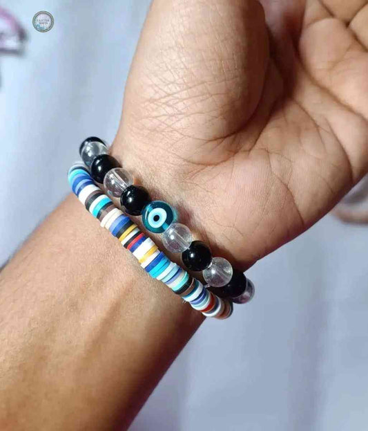 Set of 2 bracelet by Glitter Mafia featuring colorful disc beads and black and clear beads with an evil eye charm
