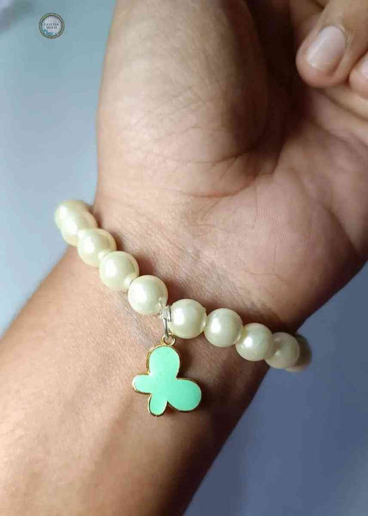 Glitter Mafia pearl beaded star bracelet with a green star-shaped charm on wrist