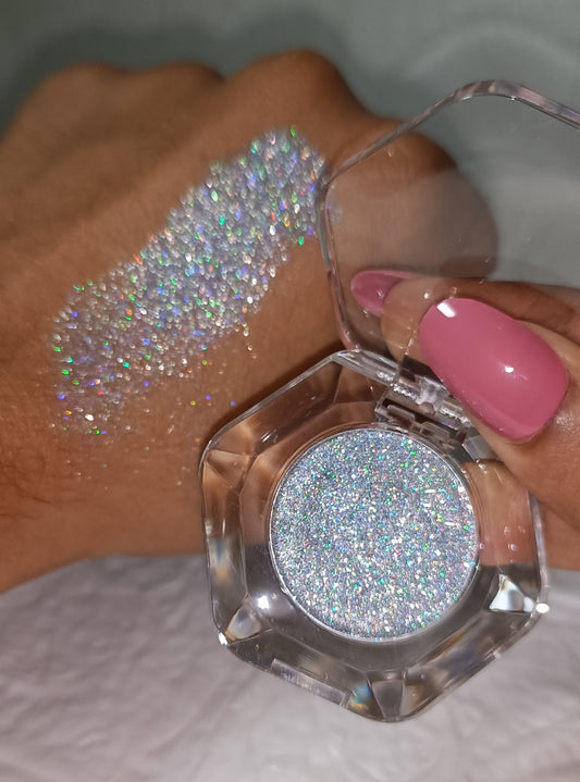 Swatch of Chromatic Crush – Multi-Chrome Molten Foil Eyeshadow. iridescent silver holographic glitter on hand and pan