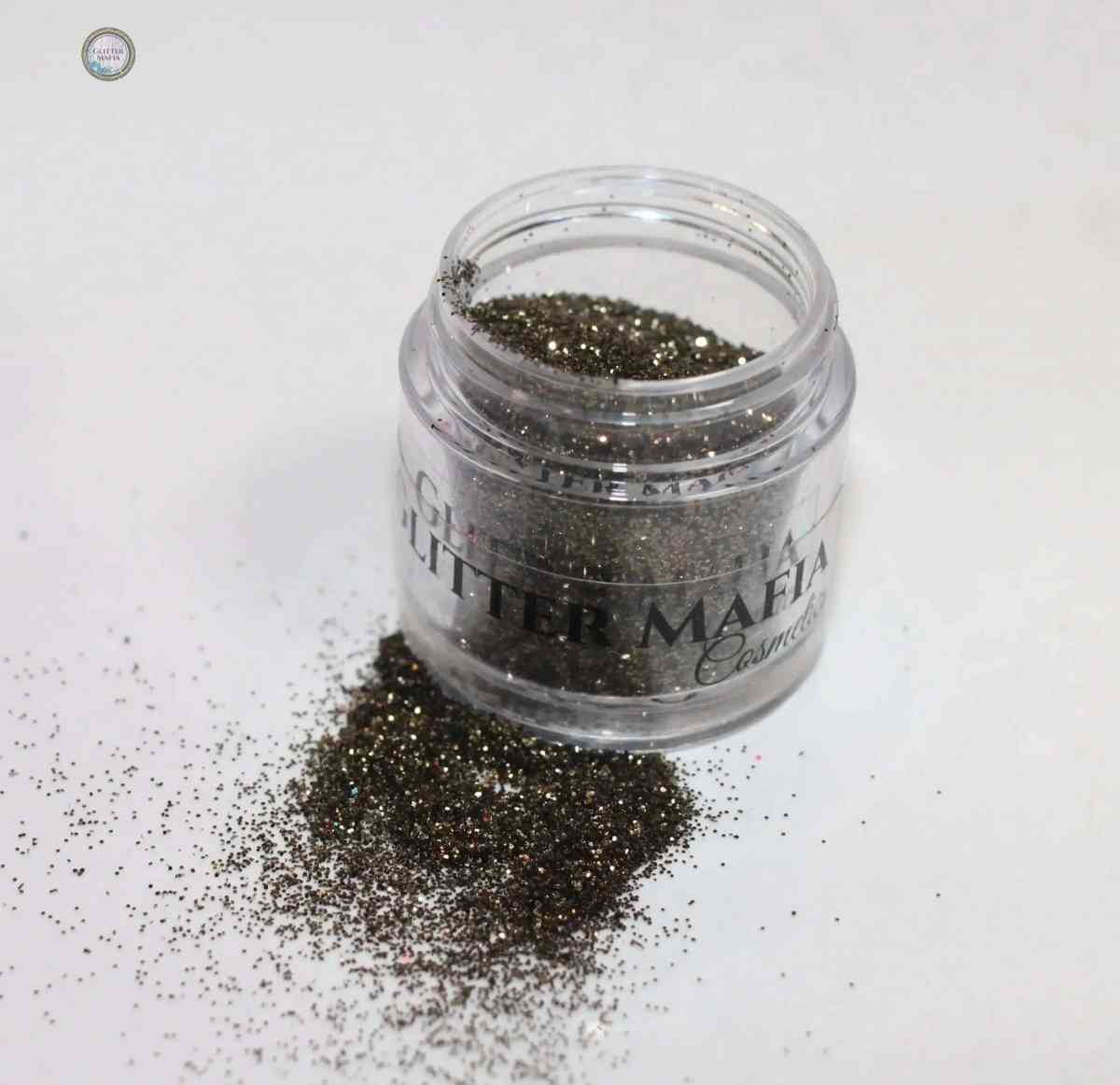 Glitter Mafia container with Forest Green Loose Glitte spilled on white surface