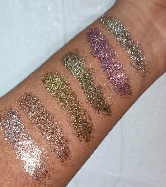 Swatches of Glitter Mafia 6-in-1 Pressed Glitter Eyeshadow in bridal and festive shades on arm